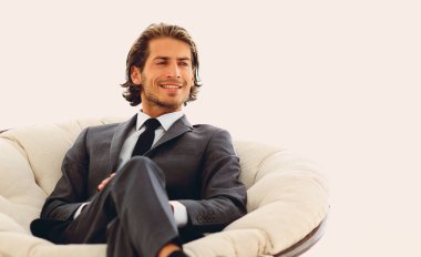 Kendine güvenen işadamı büyük bir rahat sandalyede oturuyor.