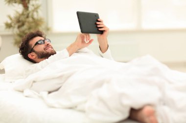 Dijital tablet ekranına bakarak closeup.sleepy adam.