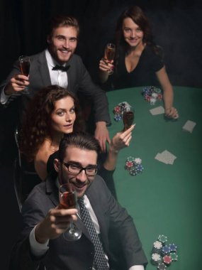 Bir grup genç zengin kumarhanede poker oynuyor.