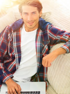 dizüstü bilgisayarda çalışan ve kameraya bakarak başarılı adam. Yukarıdan görüntülemek