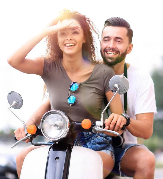 Красивая молодая пара улыбается во время езды на скутере — стоковое фото