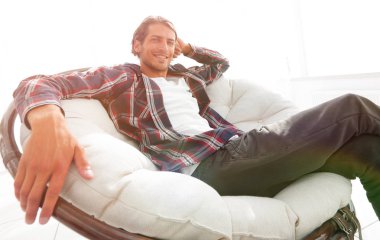 ciddi adam büyük bir rahat sandalyede oturma dayanmaktadır. yan görünüm.