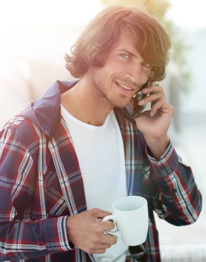 güzel bir fincan adamla bir dizüstü bilgisayar önünde oturur.