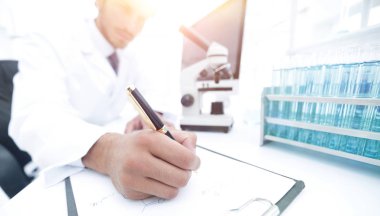 Bilimadamı laboratuarda bir deney notu yazar.