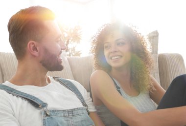 Yeni evliler yeni bir dairede kanepede oturuyor..