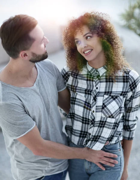 mutlu genç çift birbirlerine sarılıyor.