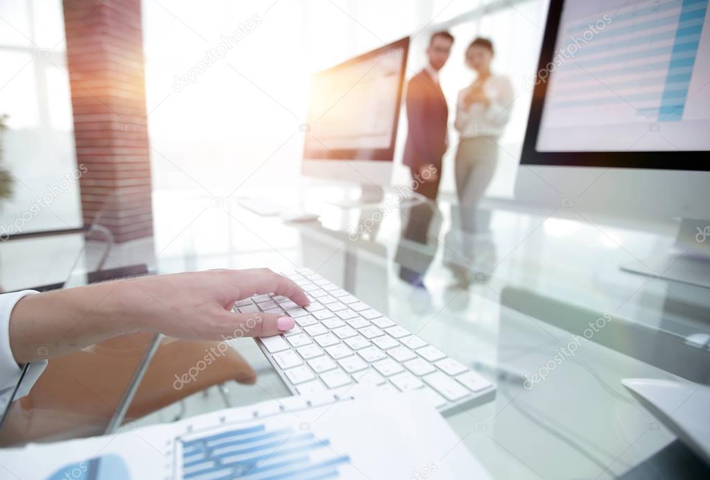 close-up of financial charts and computer keyboard on the desktop