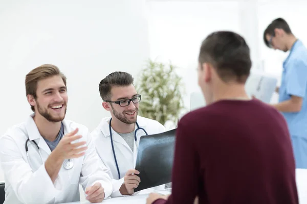 Лікарі обговорюють з пацієнтом рентген — стокове фото