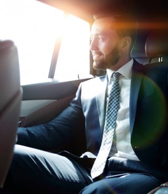 bir arabanın arka koltuğunda oturan işadamı