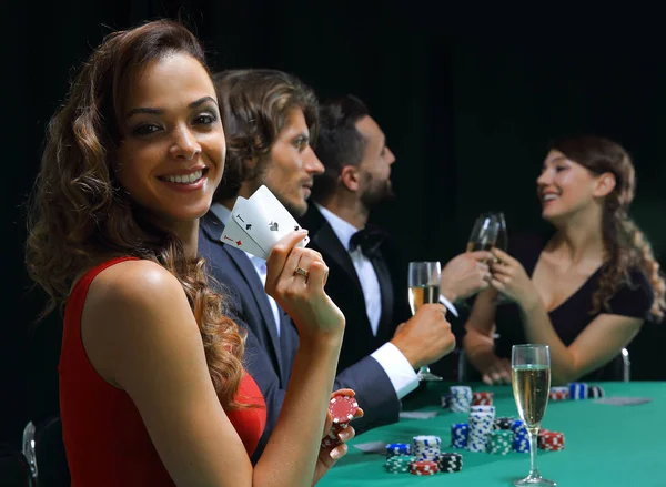 Unga brunett kvinna som spelar poker på svart bakgrund — Stockfoto