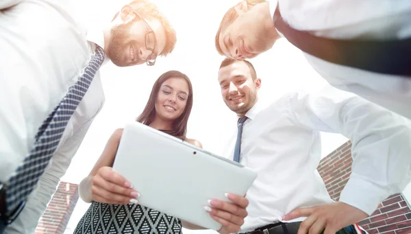 Вид снизу бизнес-команды, глядя на цифровой планшет — стоковое фото