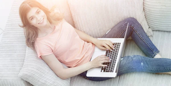 Meisje student werkt met de laptop op de bank zitten en kijken — Stockfoto