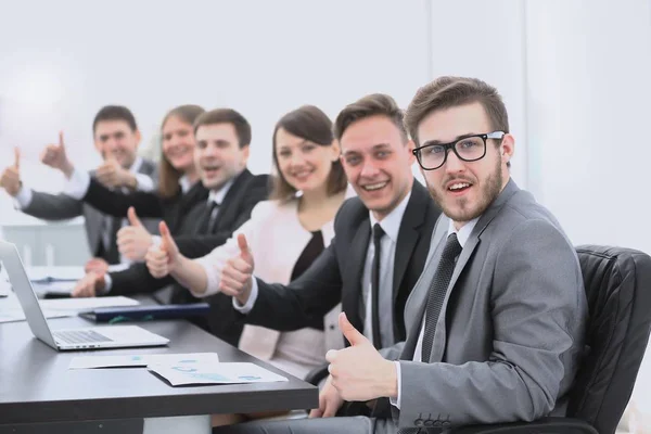 Business team met duimen omhoog zittend op zijn Bureau — Stockfoto