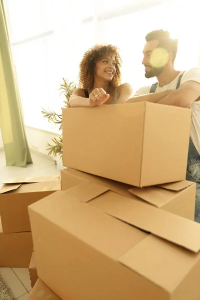 Joyeux couple debout près des boîtes dans leur nouvel appartement . — Photo