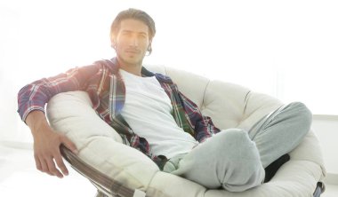 başarılı adam modern oturma odasında dinleniyor.