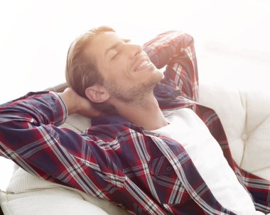 Modern adam büyük bir rahat sandalyede oturuyor dinleniyor. yan