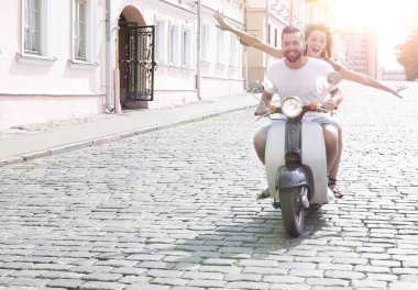 mutlu genç bir çift bir scooter üzerinde eğleniyor