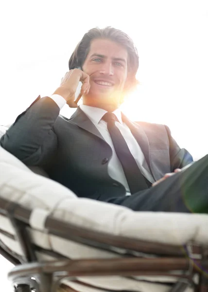 Biznes człowiek rozmawia na smartfonie siedząc w komfor — Zdjęcie stockowe
