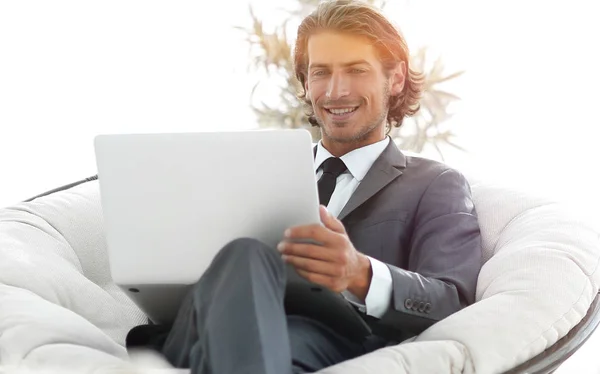 Exitoso hombre de negocios con portátil sentado en una gran comodidad — Foto de Stock