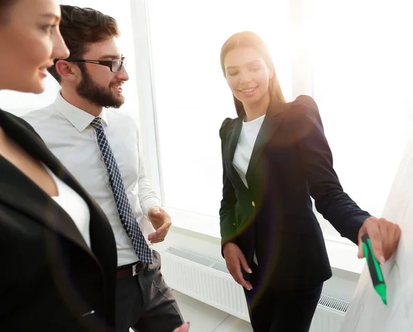 Mujer de negocios señalando con un marcador en el rotafolio — Foto de Stock