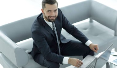 mali grafikler ile bir dizüstü bilgisayar üzerinde çalışan iş adamı