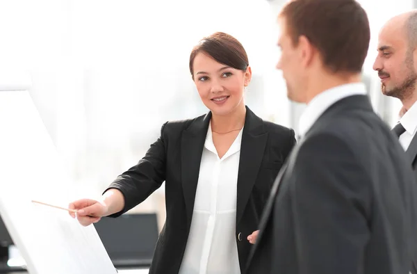 Geschäftsfrau zeigt einem Geschäftsteam Informationen auf dem Flipchart — Stockfoto