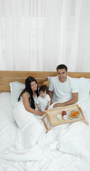 Matka, otec, dítě na lůžku v pokoji — Stock fotografie
