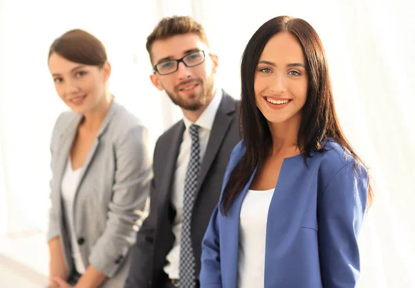 Business woman smiling with her colleagues in the background — Stock Photo, Image