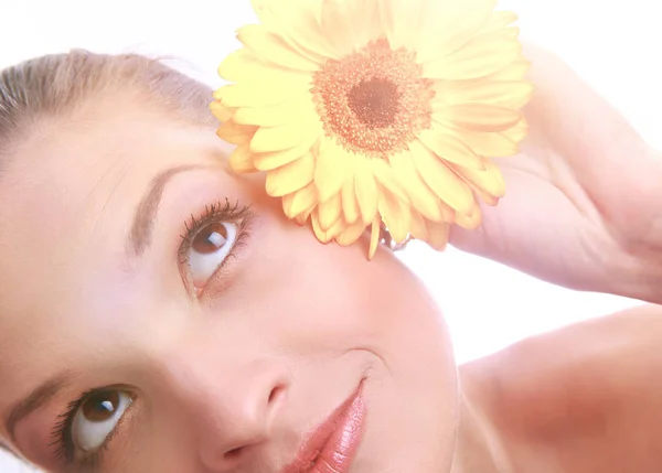 Mladá krásná žena s žlutým květem izolovaných na bílém — Stock fotografie