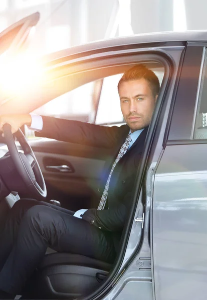 Geschäftsmann sitzt hinter dem Steuer eines Autos, auf dem Parkplatz — Stockfoto