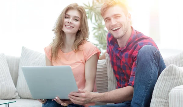 Pareja sonriente descansando en casa, sentada en el sofá . — Foto de Stock