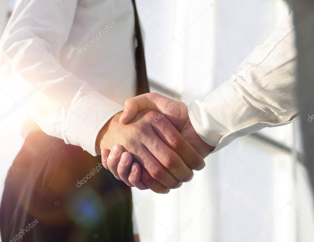 Closeup of a business handshake, on bright  background