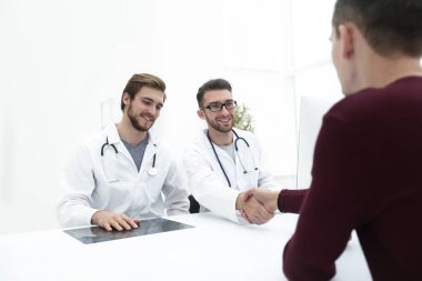 Bir el sıkışma onun hasta veren kliniğinde doktor gülümseyen