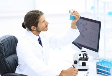 Kimya Lab bilim adamı bir şişeye bir madde ile ele alıyor.