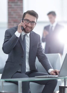 genç işadamı cep telefonu üzerinde müşterilerle konuşurken görüntüsünü