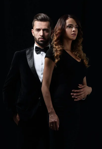Eleganter Mann und Frau posieren nebeneinander im Studio. — Stockfoto
