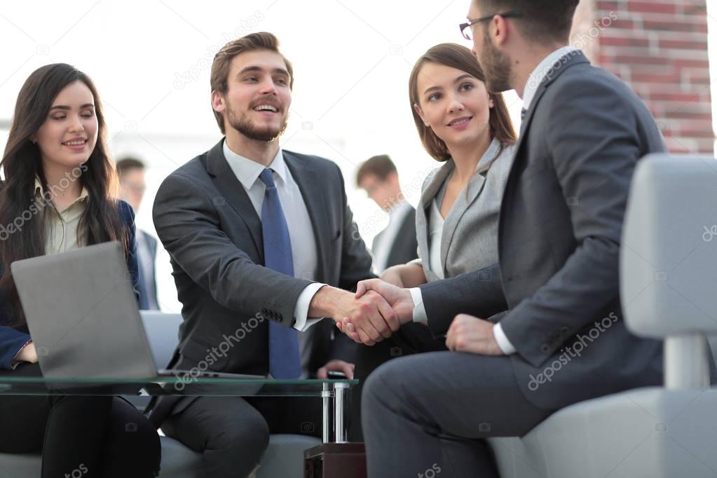 Two colleagues handshaking after meeting.