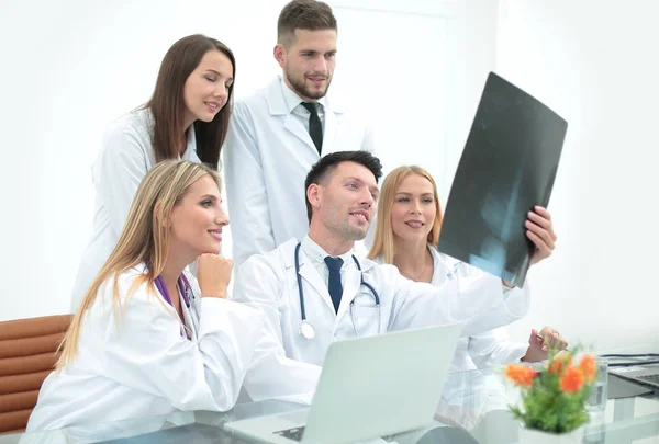 Група лікарів, які обговорюють рентгенівські промені, сидять за столом . — стокове фото