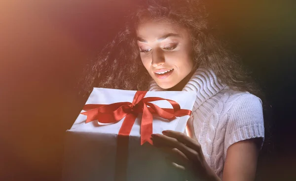 Retrato de una hermosa joven morena mirando en una caja de regalo —  Fotos de Stock