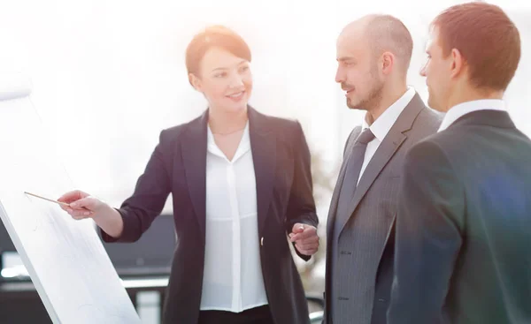 Business woman showing a business team information on the flipchart — Stock Photo, Image