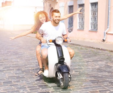 mutlu genç bir çift bir scooter üzerinde eğleniyor