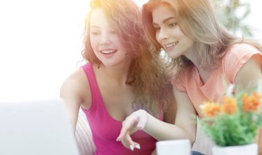 iki genç kadın bir kahve oturan dizüstü bilgisayar ile video tartışmak