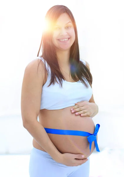 Happy pregnant woman measuring her tummy and waist. — Stock Photo, Image