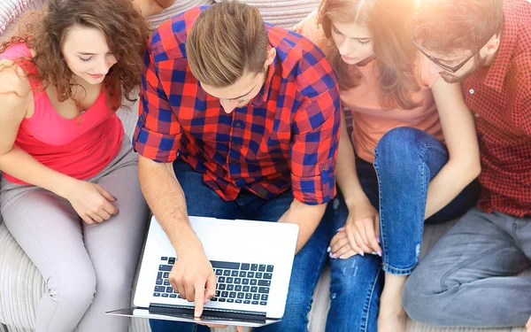 Gruppo di amici con laptop seduti sul divano . — Foto Stock