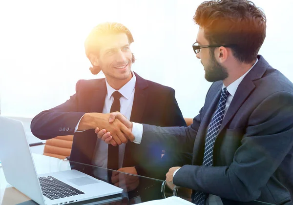 Handshake homem de negócios sentado atrás de uma mesa . — Fotografia de Stock