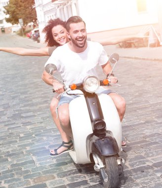 mutlu genç bir çift bir scooter üzerinde eğleniyor