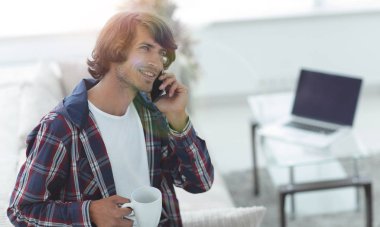 güzel bir fincan adamla bir dizüstü bilgisayar önünde oturur.