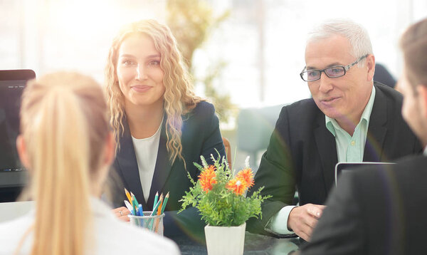 Группа уверенных деловых партнеров обсуждают бумагу в mee
