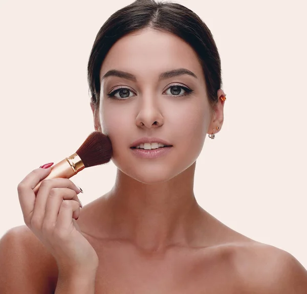 Close-up de uma mulher bonita com uma escova de maquiagem — Fotografia de Stock