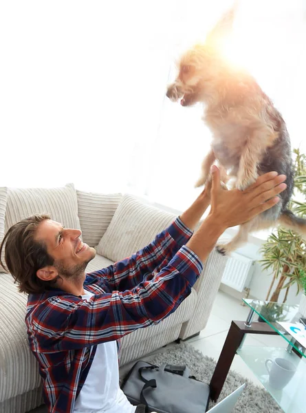 넓은 거실에 그의 강아지와 함께 재생 하는 현대 젊은이 — 스톡 사진